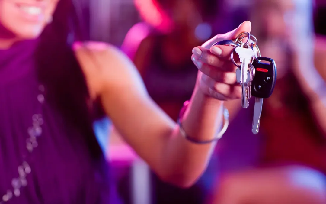 Friend handing over car keys to a designated driver on a night out