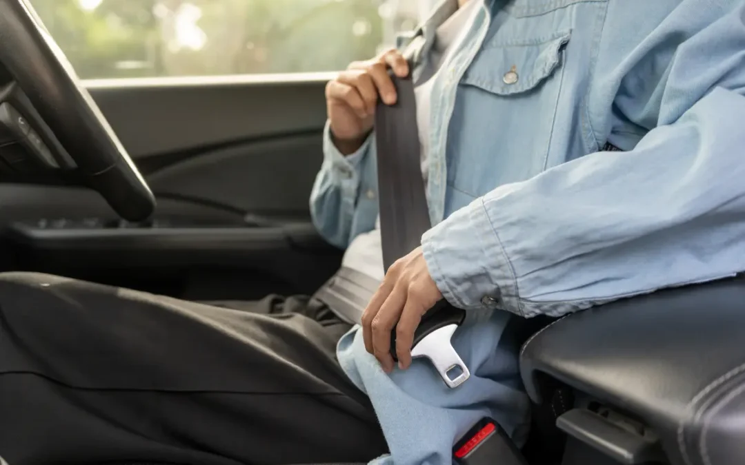 A driver puts on their seatbelt.