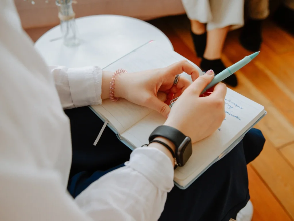 A counselor listens attentively and takes notes during a session.