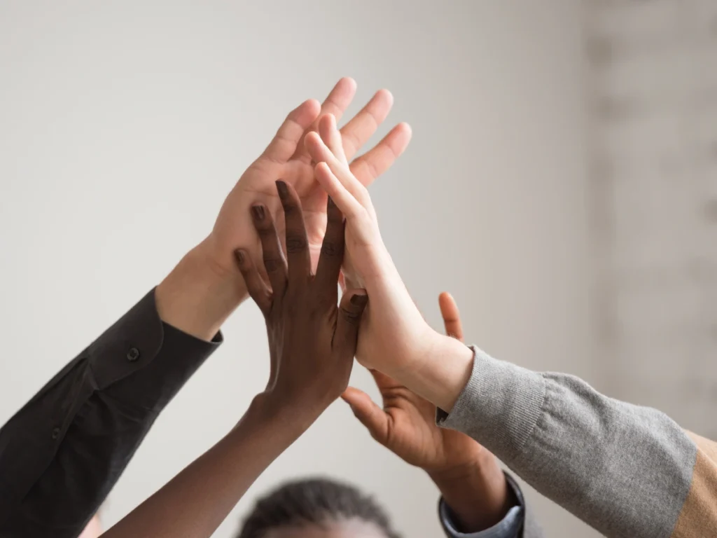 A supportive group celebrates progress with high fives.