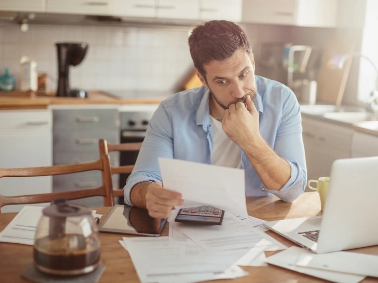 A man trying to figure out his expenses after knowing how much a DUI costs in Arizona.