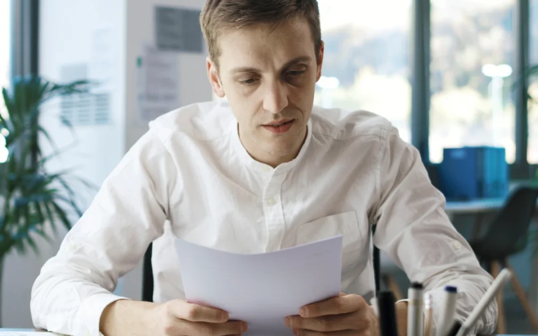A man reading his DUI paperwork at a desk.